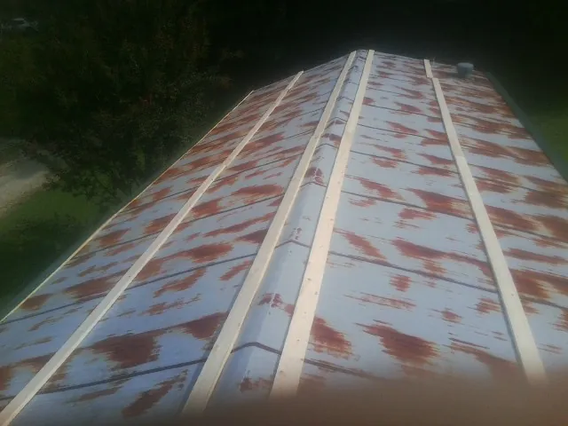Rusted metal roof panels with new wood purlins before replacement — Storm Damage Roof Repair in Athena by Roofing Brothers