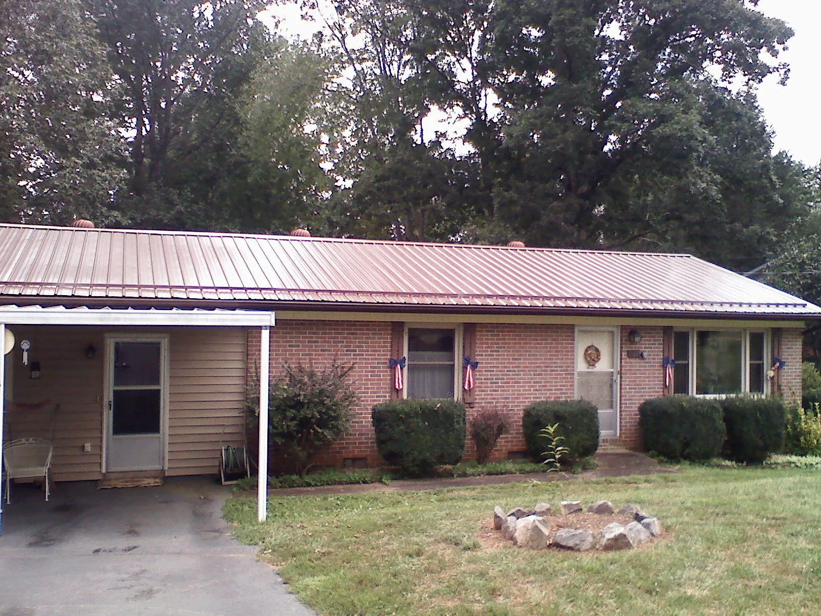 Bronze metal roof and carport on a brick ranch home — Roof Repair work by our crew in Athena